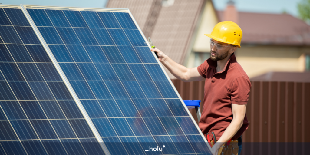 Homem com o capacete protetor segurando uma placa solar
