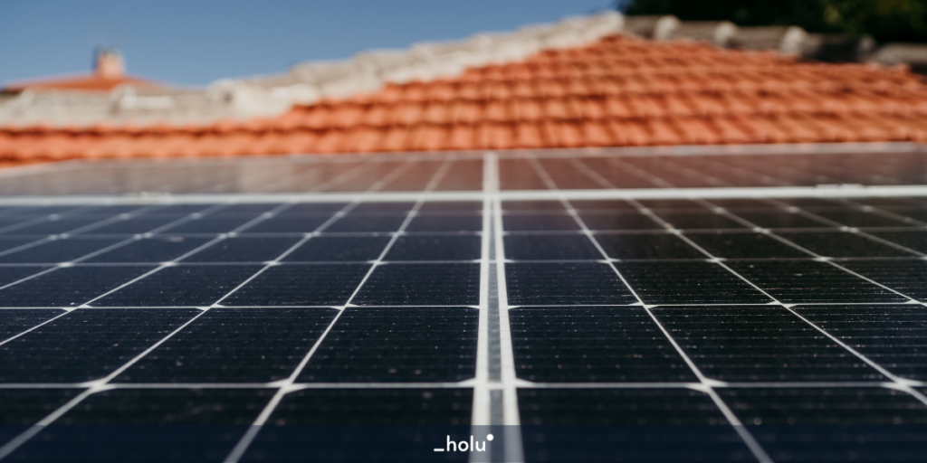 Detalhes das linhas das placas solares aproximadas na imagem, com fundo destacado de um telhado laranja.